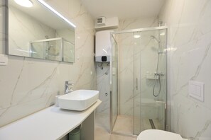 A modern bathroom with a glass-enclosed shower, a white sink, and a large mirror. - Hedera Estate, Hedera A12 (Dubrovnik)