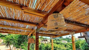 Eine Holzupergola mit einem Wendelventilator.