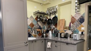 Una cocina con gabinetes grises, encimera de mármol y una variedad de electrodomésticos y utensilios de cocina.