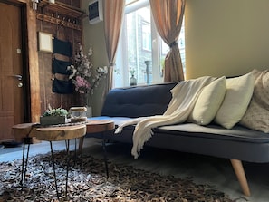 Relax in this inviting living room with a sofa, table, and plant.