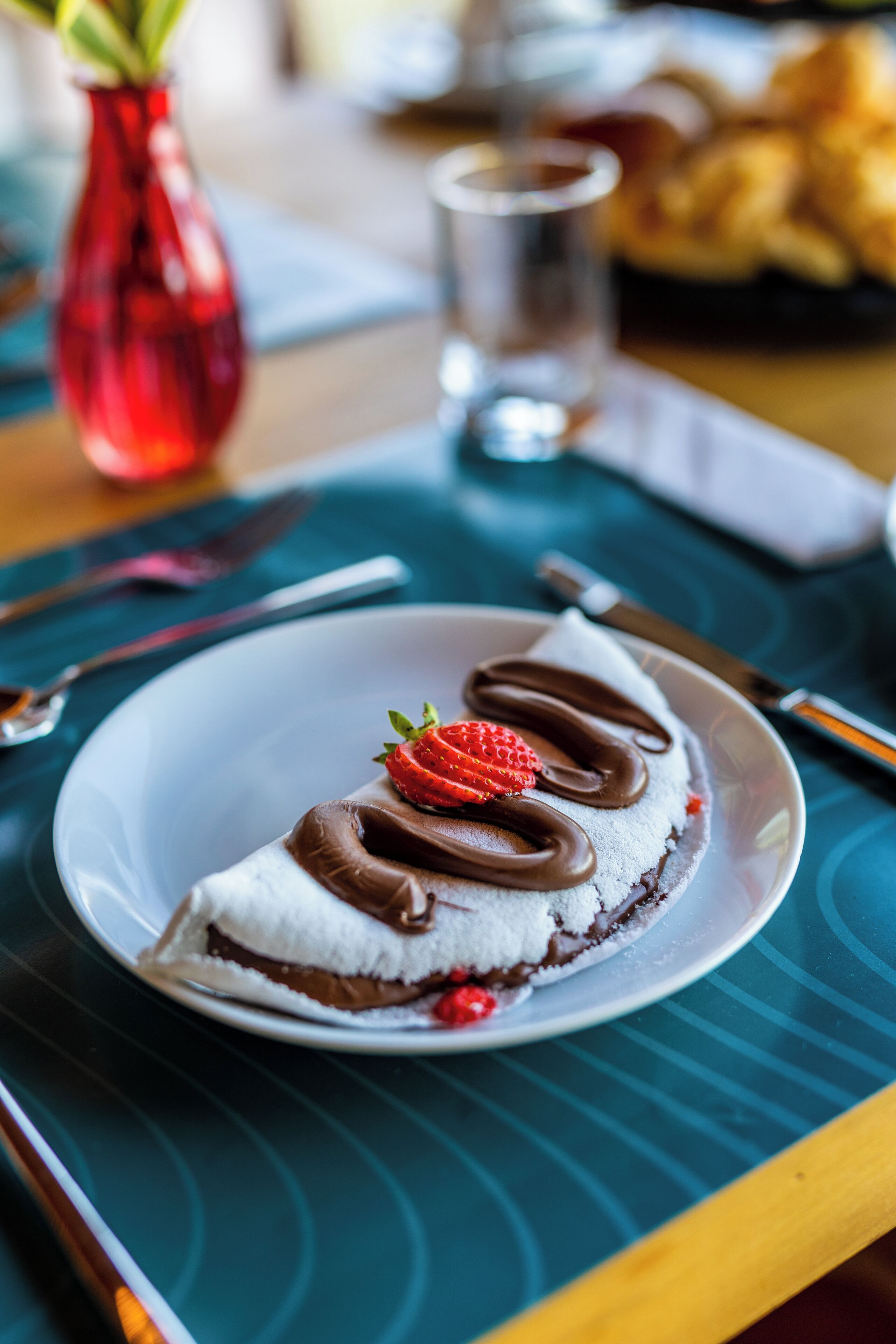 Ein Dessert auf einem Teller mit einem Löffel und einer Gabel daneben.