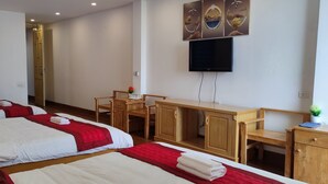 A hotel room with two beds, a desk, a television, and a small table with a plant. - Thanh Huong 99 Hotel - Noi Bai (Hanoi)