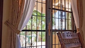 A room with a sliding glass door leading to a balcony, a wooden chair, and an air conditioning unit. - Peaceful culdesac orchid villa, pool, work ergo (Puerto Plata)