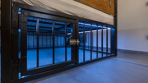 A metal gate with a lock, leading to a room with a concrete floor and a wooden ceiling. - Luxury In perfect Downtown, specially designed for groups (Budapest)