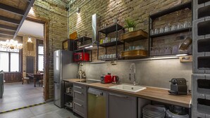 A modern kitchen with a brick wall, stainless steel appliances, and wooden countertops. - Luxury In perfect Downtown, specially designed for groups (Budapest)