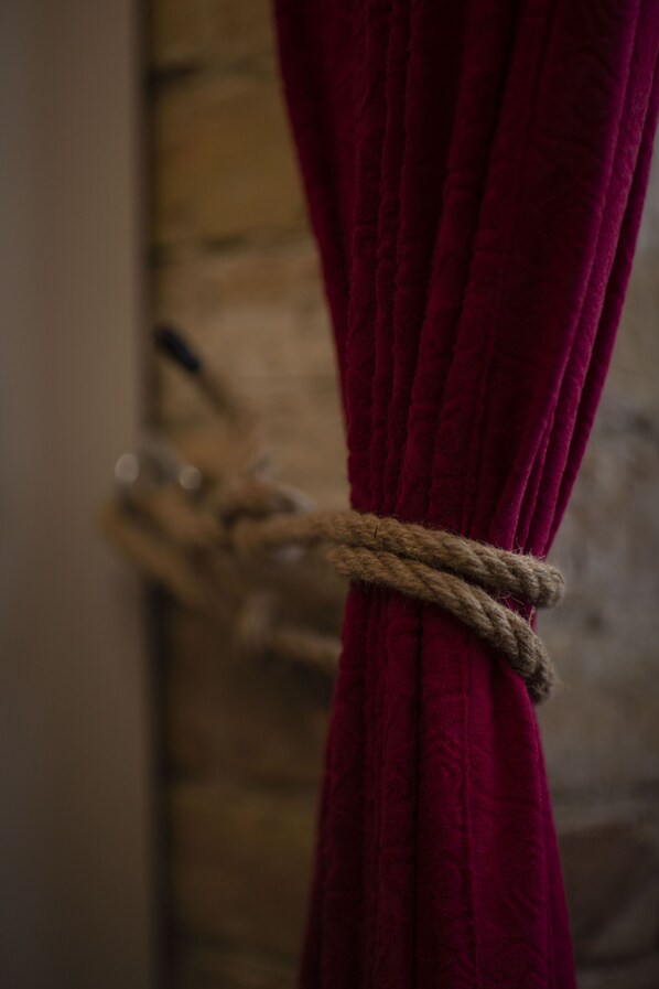 A close-up of a red curtain tied with a rope.