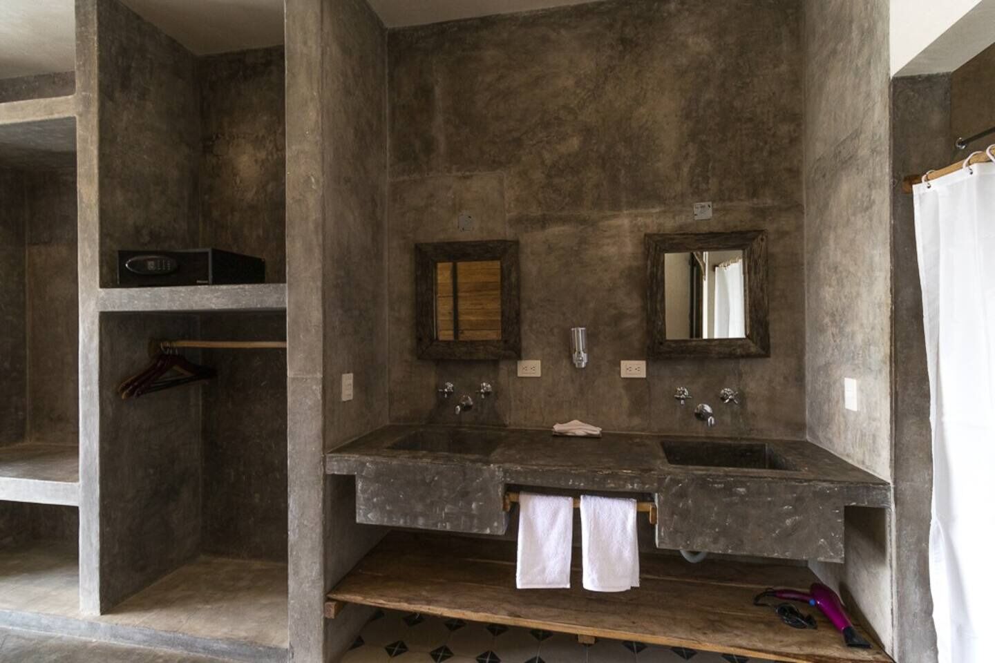 A bathroom with two sinks, a mirror, and a towel rack.