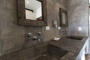 A bathroom with two sinks, a large mirror, and a shower.