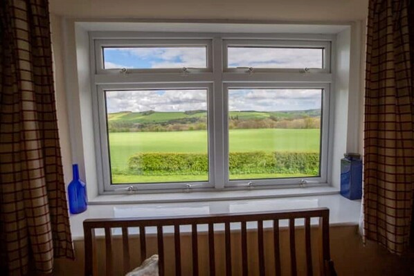 A room with a large window overlooking a green landscape. - Wild Rose in rural location with lovely views on a working farm with walks (Jedburgh)