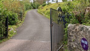 Une entrée fermée par un portail mène à une propriété sur laquelle est apposée une plaque indiquant « Mars Hill 11 ».