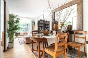 Enjoy meals in this dining area with a table for four, a mirror above, and a potted plant nearby.