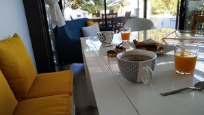 A dining table with a coffee cup, a glass of orange juice, and a plate of food.