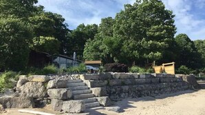 A stone staircase leading up to a building surrounded by trees. - Swim Spa cottage on a Private Beach (Fort Erie)