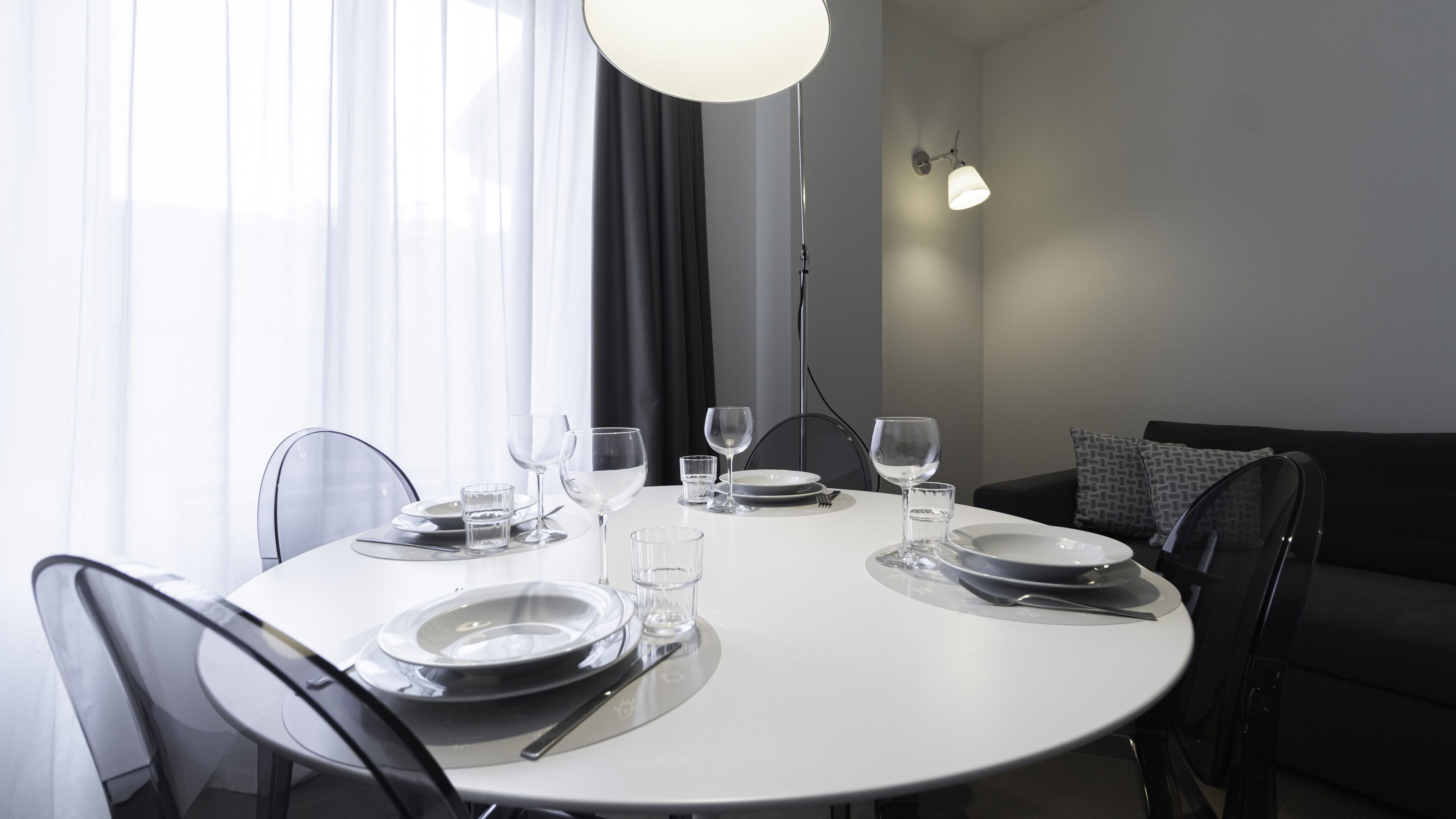 A dining area with a round table set for four, including plates, glasses, and cutlery.
