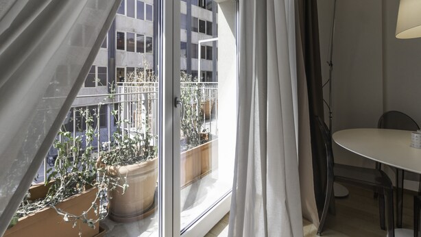 A room with a balcony, a table, and chairs. - Italianway - Corso Como 11 (Milan)