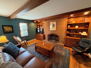 A living room with a fireplace, a television, a sofa, and a coffee table.