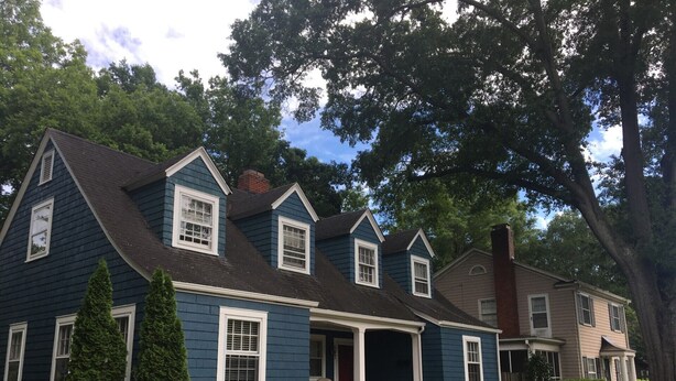 A two-story house with a dark blue exterior, white trim, and a front porch. - Colorful Downtown Historic 2BR Shingle Home (Spartanburg)