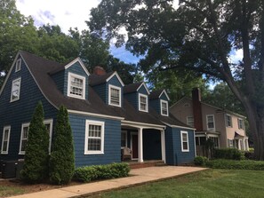 A two-story house with a dark blue exterior, white trim, and a front porch.