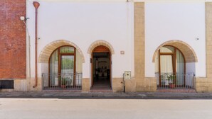 Un edificio con tres ventanas arqueadas y una entrada central.