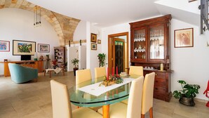 A dining area with a glass table, chairs, and a wooden cabinet with glass doors. - 3278 Guest House Eleonora - Family by BarbarHouse (Alliste)