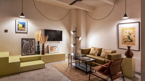 Ein modernes Wohnzimmer mit einer Couch, einem Couchtisch und Kunstwerken an den Wänden.