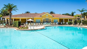 A resort with a large pool, sun loungers, and a yellow building with a tiled roof. - Pretty & Welcoming Resort Condo (Kissimmee)