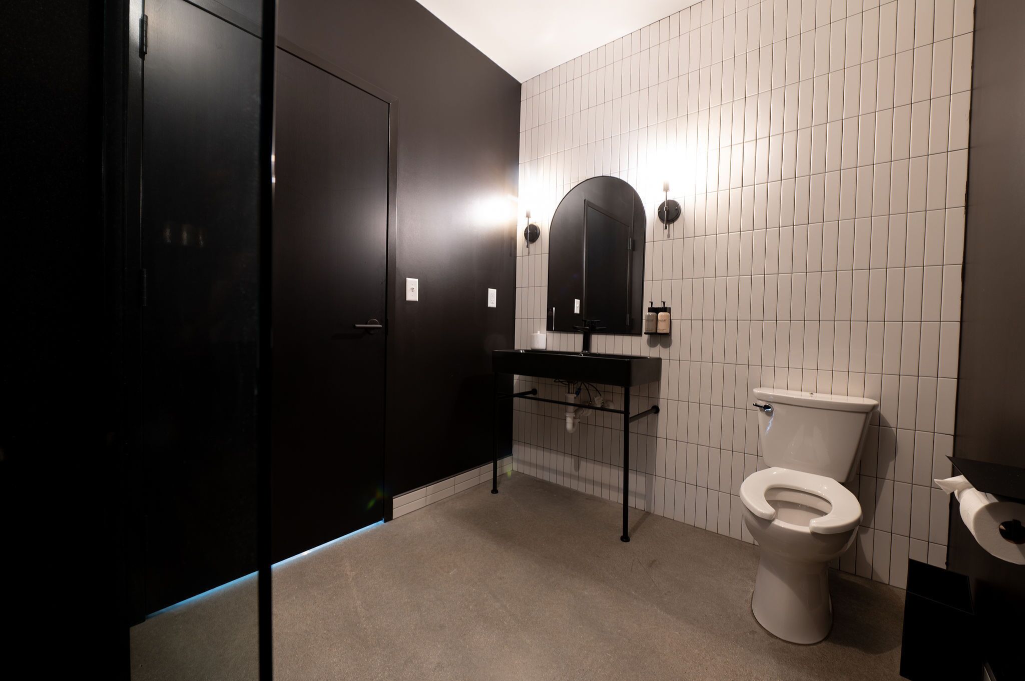A bathroom with a toilet, a sink, and a mirror.