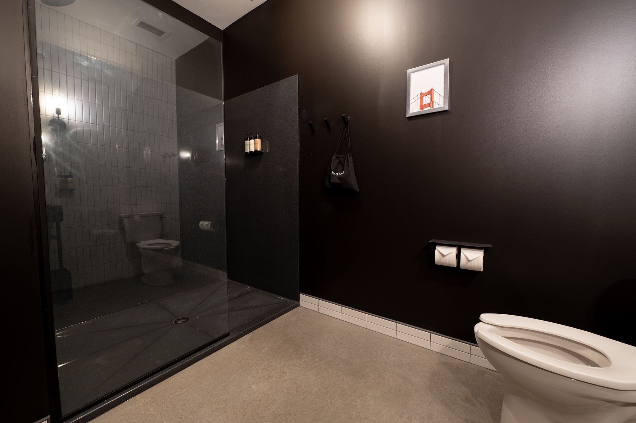 Un baño moderno con cabina de ducha de vidrio, inodoro y lavamanos.