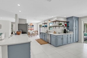 Une cuisine moderne dotée d’un îlot central, de meubles de rangement intégrés et d’un coin repas avec une table et des chaises.