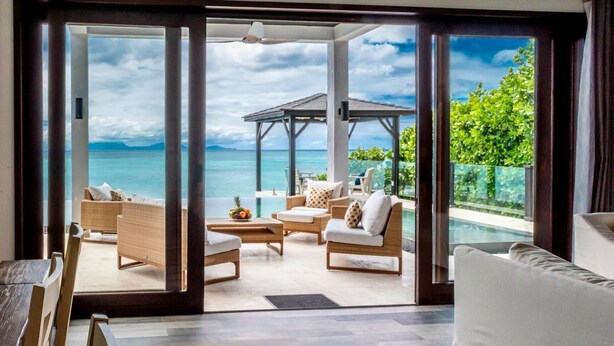 A spacious room with a large sliding glass door leading to a private outdoor area with a pool and a gazebo. - Tamarind Hills Resort - Barracuda 8 (Antigua and Barbuda)