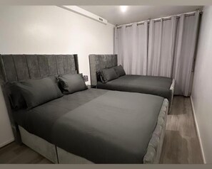 Une chambre avec deux lits, chacun doté d’une tête de lit et d’oreillers.