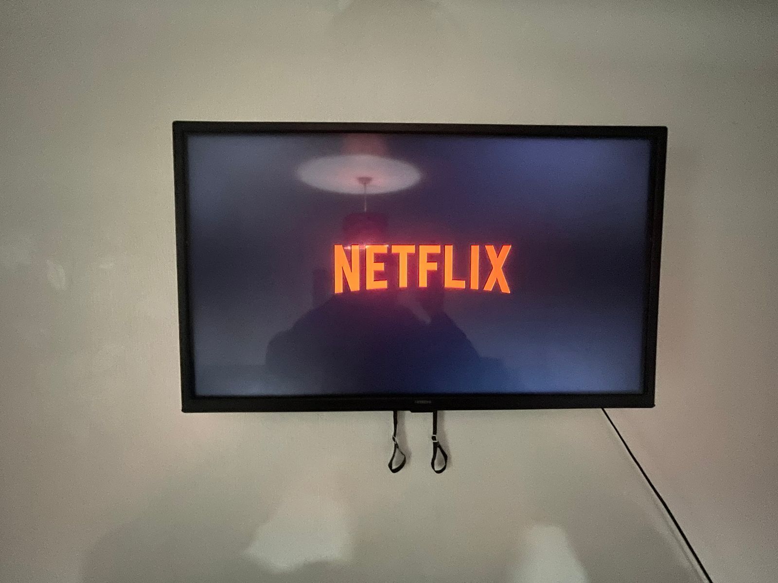 A wall-mounted television displaying the Netflix logo.