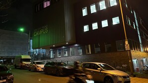 A building with a sign reading "VINCENT ROAD CAMPUS" at night, featuring multiple windows and a streetlight. - New! Xtra Large 4 Bedroom Up to 14 Guests (London)