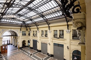 A spacious interior with a high ceiling, large windows, and a checkered floor pattern.