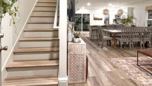 A staircase leading to a dining area with wooden flooring and a central island.
