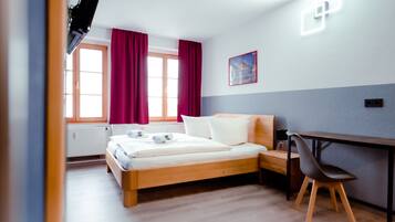 Ein Schlafzimmer mit einem hölzernen Bett, einem Schreibtisch und einem Stuhl.