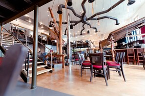 A spacious interior with a high ceiling, exposed ductwork, and a central staircase. - Restaurant und Pension Alberthafen (Dresden)