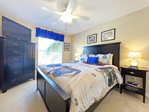 A bedroom with a bed, a nightstand with a lamp, a dresser, and a ceiling fan. - Large pool home with spa - Gated West Haven Resort (Davenport)