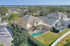 Un quartier résidentiel avec des maisons, une piscine et une cour clôturée.