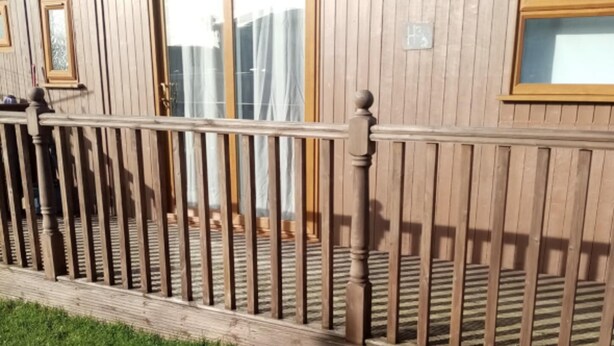 A wooden house with a fenced porch and a grassy yard. - Chalet Retreat in Mablethorpe (Mablethorpe)