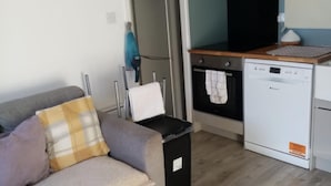 A compact living space with a kitchenette, including a stove, oven, and dishwasher. - Chalet Retreat in Mablethorpe (Mablethorpe)