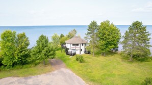 A light house with a sign, surrounded by trees and a body of water. - Your Superior Vacation Destination  (Ontonagon)