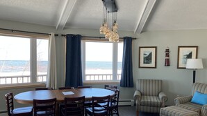 A dining area with a round table and chairs, a sofa, and a lamp. - Your Superior Vacation Destination  (Ontonagon)