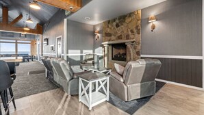 Un salon moderne avec des canapés en cuir, une cheminée en pierre et une vue sur l’océan.