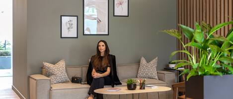 A modern living room with a sofa, a coffee table, and a potted plant.