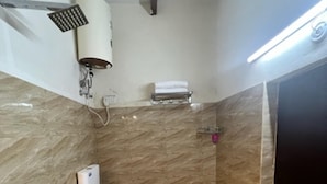 Une salle de bain équipée de toilettes, d’une douche et d’un sèche-mains.