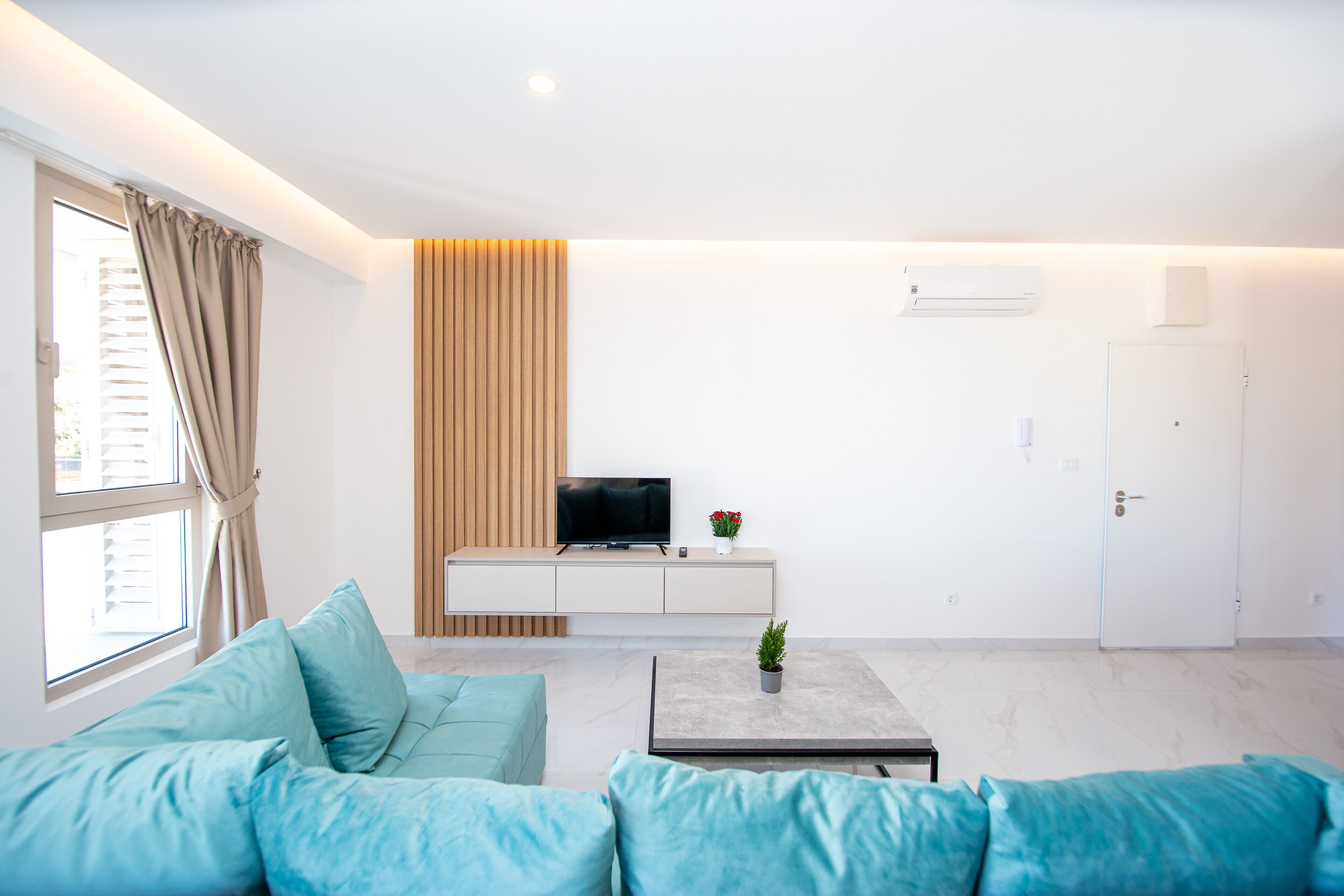 A modern living room with a sofa, a coffee table, a TV, and a cabinet.