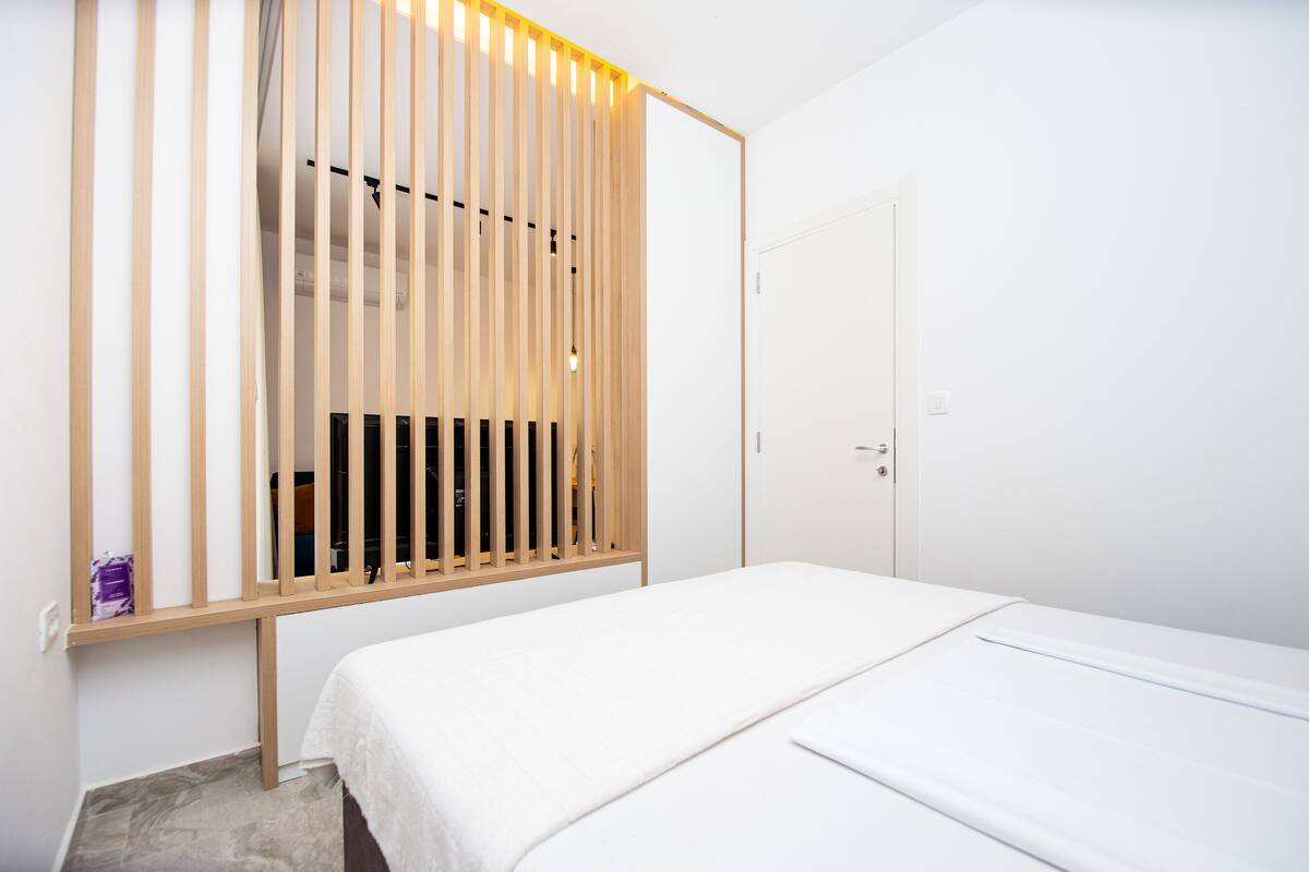 A bedroom with a bed, a wardrobe, and a door.