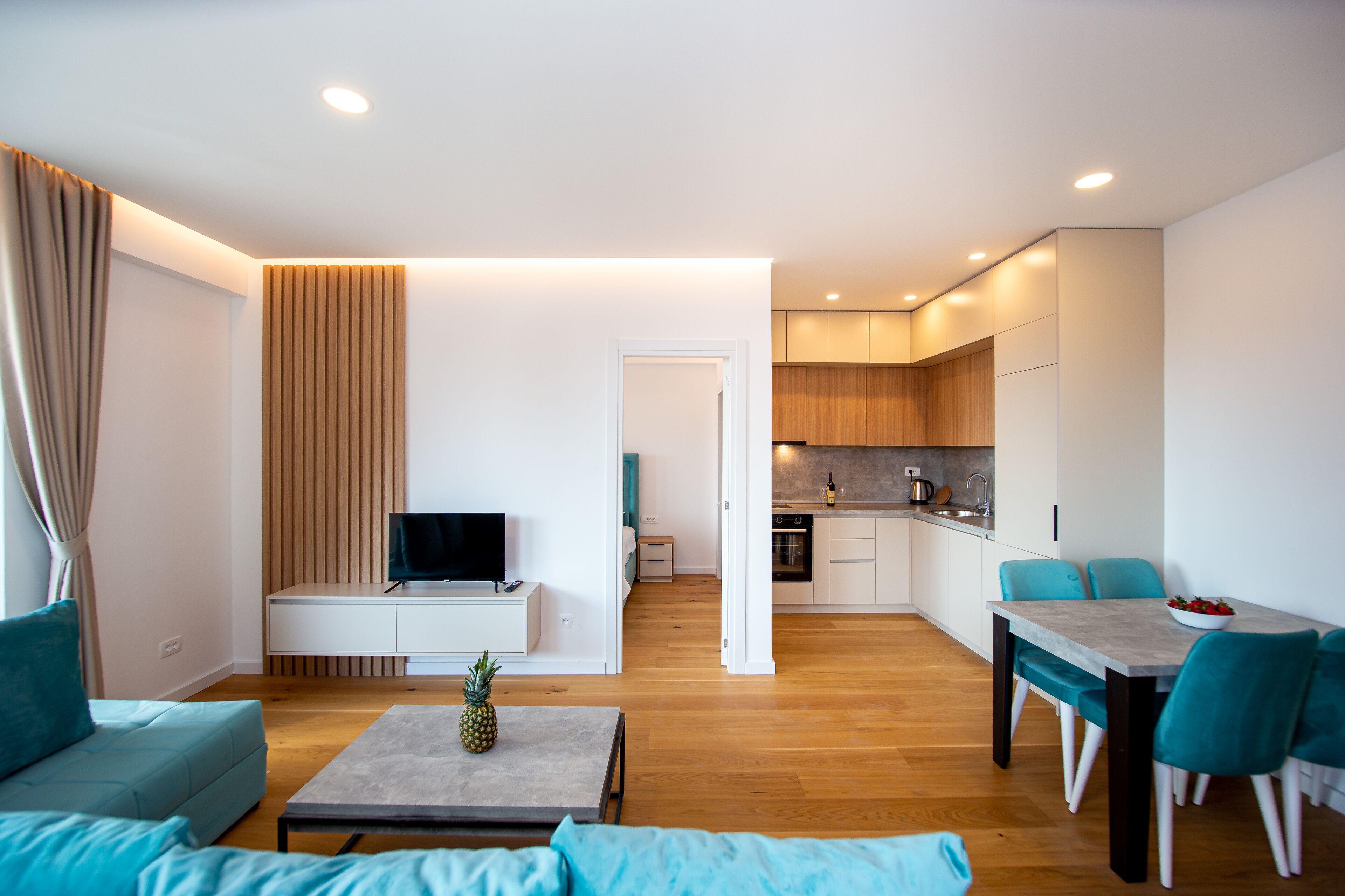 A modern apartment with a living room, dining area, and kitchen.