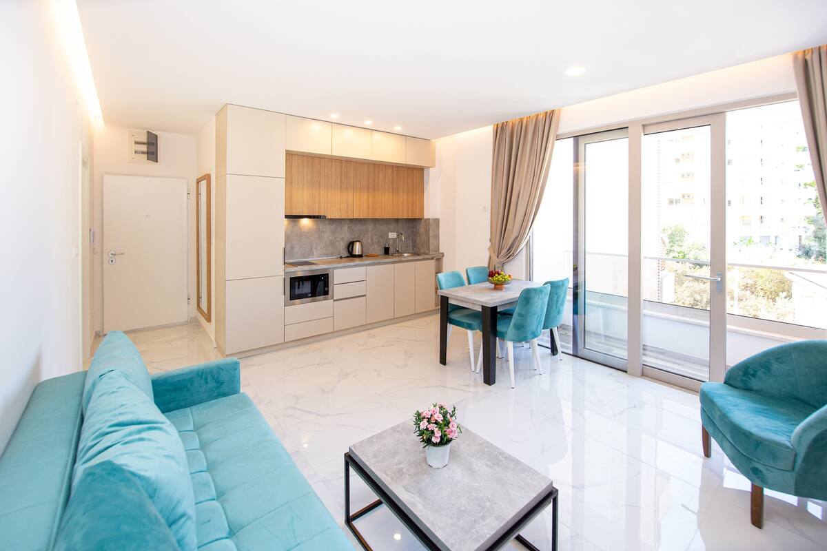 A modern apartment with a kitchen, dining area, and living room.
